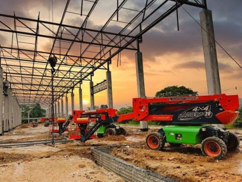Plataforma elevatória em um terreno de terra sob uma estrutura de aço ao entardecer